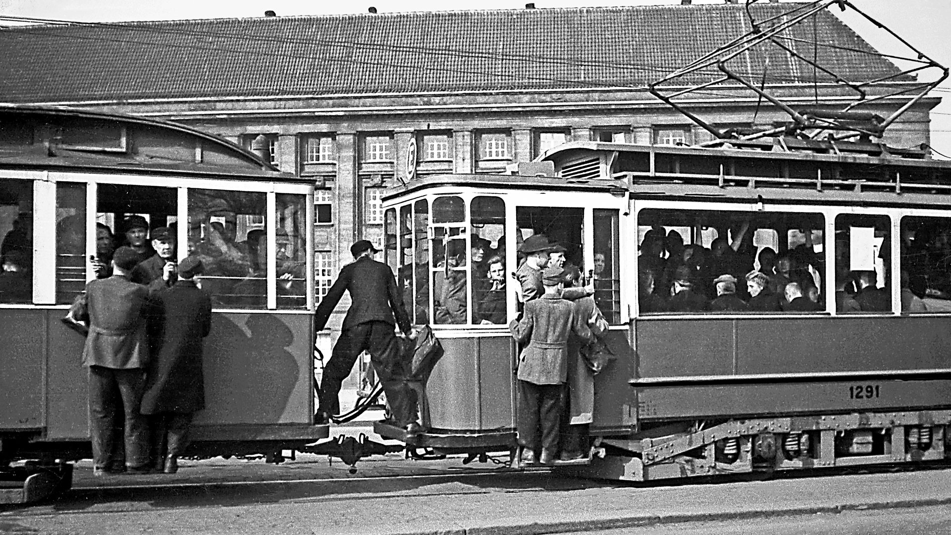 alte Straßenbahn mit Trittbrettfahrern, Anfang 20. Jahrhundert, schwarz-weiß